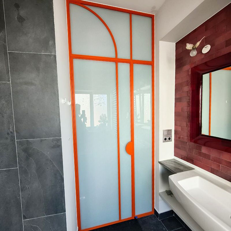 Pomarańczowe drzwi loftowe ze szkłem ryflowanym