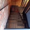 Perforowane stopnie schodów stalowych w stylu loft z widokiem z góry na nowoczesną konstrukcję i ceglaną ścianę