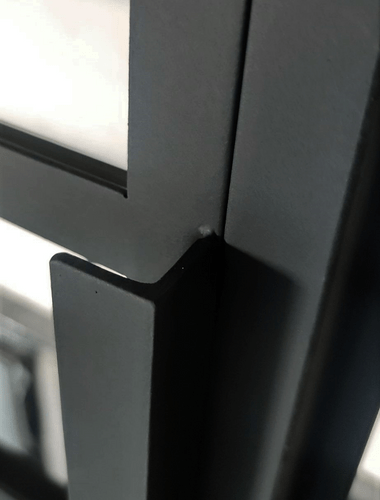 Stalowa konstrukcja drzwi loftowych wykończona czarną farbą